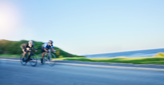 Blur motion, sports and people cycling on bicycle for race, competition or marathon training. Fitness, fast and team of athlete cyclists riding a bike for speed practice on a mountain road in nature.