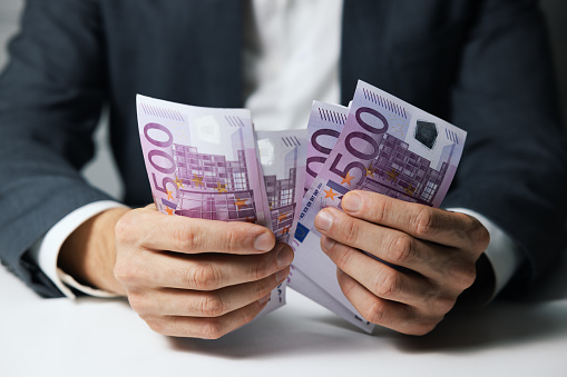 closeup of businessman hands counting 500 euro money banknotes