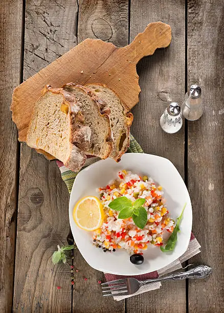 Risotto with vegetables and bread on a wooden background