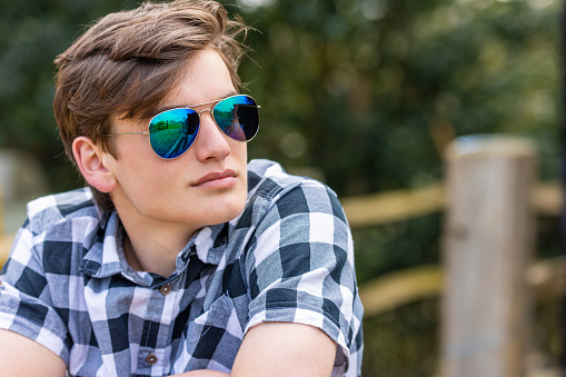 Man teenager teen male young adult outside wearing aviator sunglasses