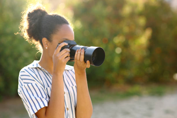istock Black photographer taking photos in a park 1791492078