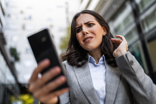 Worried angry businesswoman using phone