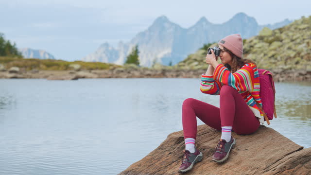 Woman with camera  sitting  at the lake in Austria
