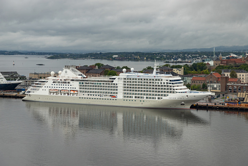 Oslo, Norway, July 6, 2023 - Sky Princess cruise ship in Oslo harbor, Akershus fortress in the background.