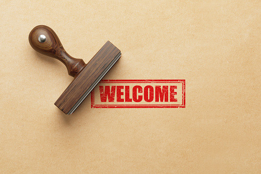 Welcome stamp on Kraft paper background. Horizontal composition.
