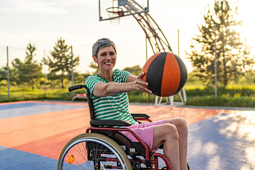 Portrait of senior woman in wheelchair on the basketball court