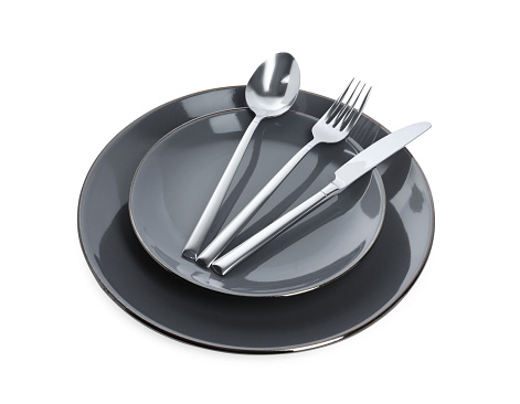 Plate with shiny silver cutlery on white background