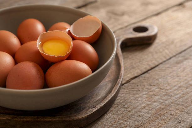 istock Bowl with raw chicken eggs on wooden table, closeup. Space for text 1791586266