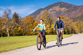 Woman and man riding bikes and enjoying nature on a fall sunny day