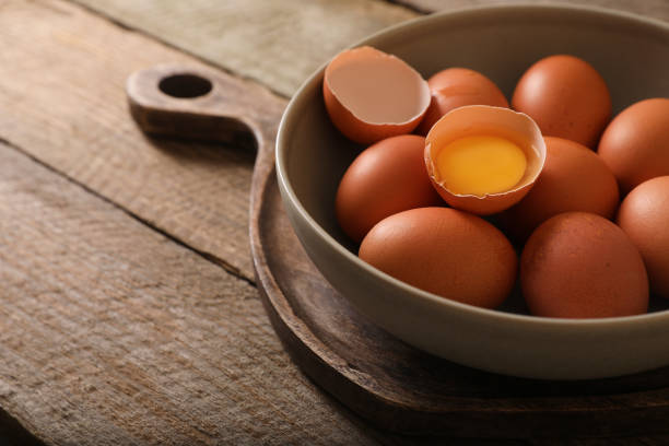 istock Bowl with raw chicken eggs on wooden table, closeup. Space for text 1791586298