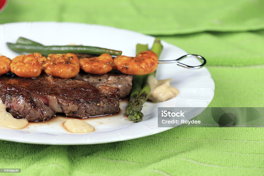 Surf and Turf Skewered Chillie Garlic Prawns and a beautiful succulent Oyster Steak served with grilled asparagus and grilled beans Asparagus Stock Photo