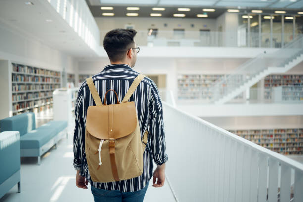 istock Backpack, library and study with a man student walking in a university bookstore for education or learning. Back, college and research with a male pupil taking a walk in search of reading books 1791587380