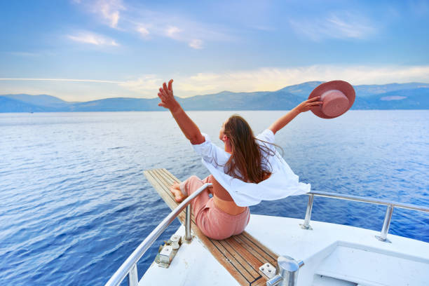 free carefree satisfied happy inspired traveler girl with open arms enjoys relaxing vacation on a white private boat in turquoise sea - sailing light wind nautical vessel imagens e fotografias de stock