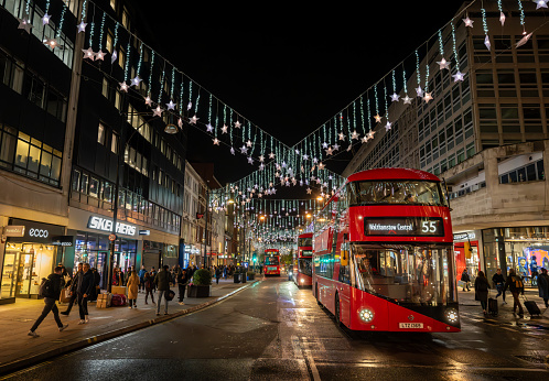 London, UK - Nov 8 2023: Oxford Street, a famous shopping street in Central London with Christmas lights and red London buses.