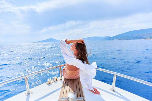 free carefree inspired rich traveler girl enjoys relaxing vacation on a luxury white private boat in the turquoise sea - sailing light wind nautical vessel imagens e fotografias de stock