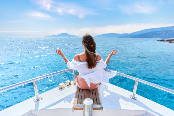 free carefree inspired traveler girl enjoys relaxing and calm private vacay on a white luxury boat in the turquoise sea - sailing light wind nautical vessel imagens e fotografias de stock