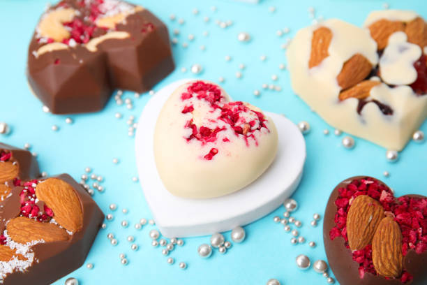 Stock photo showing a display of homemade, individual, luxury chocolate truffles with a ganache centre and coated in dehydrated raspberry pieces. These luxury chocolate balls are ideal as a birthday present.