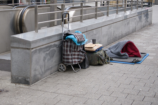 Вещи бездомного человека, лежащие рядом со входом в подземный переход