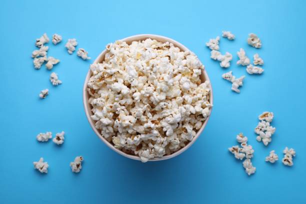 istock Paper bucket with delicious popcorn on light blue background, flat lay 1791606912
