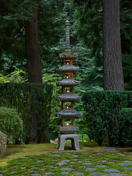 Japanese Garden Sapporo Pagoda lantern Night Candle Glow Portland Oregon A Summer night looking at a stone Pagoda lantern with candles and evergreen trees at the Portland Japanese Garden. This 18 ft tall, 5 story, 2 ton Lantern, is a traditional Buddhist pagoda. It was given to the City of Portland Oregon by its sister city Sapporo, Japan. Its named Goju-no-to and is also referred to as the Sapporo Pagoda. This Garden is located in the Pacific Northwest in in Portland, Oregon. I am a Photographer level member of the Portland Japanese Garden as required by the Garden for Commercial use of photos. portland japanese garden stock pictures, royalty-free photos & images