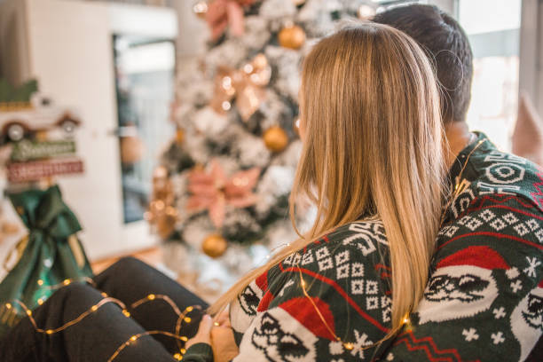istock A loving couple enjoys relaxing by the Christmas tree 1791620084