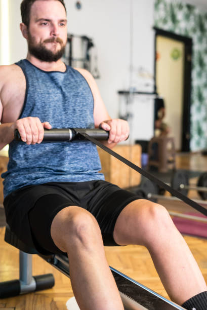 l’homme avec la barbe fait de l’exercice pour les jambes dans le sport vertical du gymnase encore - weight bench flash photos et images de collection