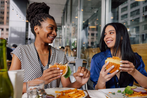 mujeres de negocios disfrutando juntas de la pausa del almuerzo - dining burger outdoors restaurant fotografías e imágenes de stock