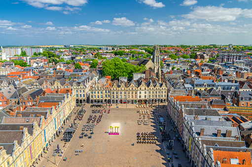 Aerial panoramic view of Arras city historical centre, Heroes Square with old Flemish-Baroque-style townhouses and John the Baptist catholic church, blue sky in summer day, Artois, Hauts-de-France