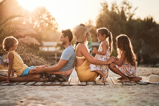 Beautiful family of five enjoying sunset on a beach vacation.