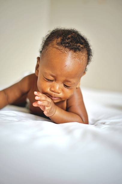 istock African American baby boy crying on a white bed. 1791647063
