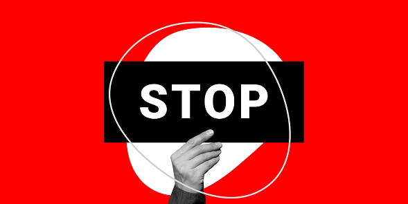 Stop concept. A hand holds a black sign that says STOP on a red background. Minimalistic art collage.
