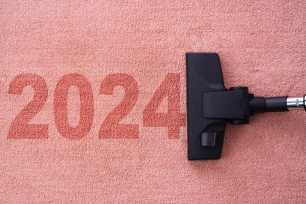 home cleaning with vacuum cleaner and copy space for a text. New year 2024 text over carpet