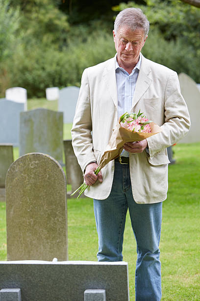 istock Man Laying Flowers on Grave 179168068