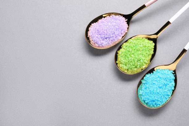 istock Spoons with colorful sea salt on light grey table, flat lay. Space for text 1791684093