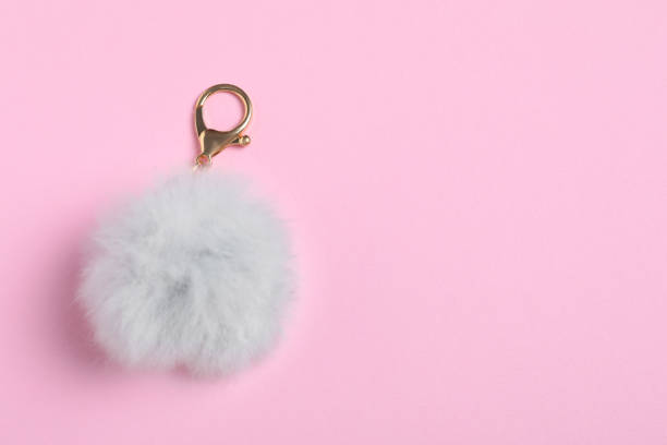 istock Gray fur keychain on pale pink background, top view. Space for text 1791684615