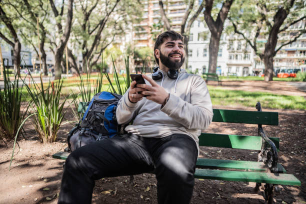 istock Young man using the mobile phone in the park 1791685710