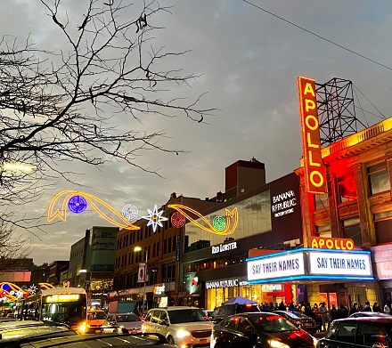 New York, NY USA - December 12, 2020 : View of the Harlem Holiday Lights illuminated over 125th Street next to the Apollo Theater marquee with the message 