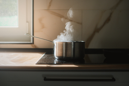 Steam coming out of a saucepan with boiling water