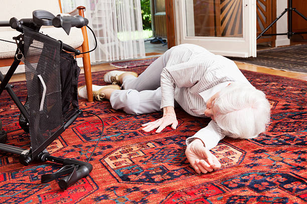 accident senior woman after fall lying on ground stock photo