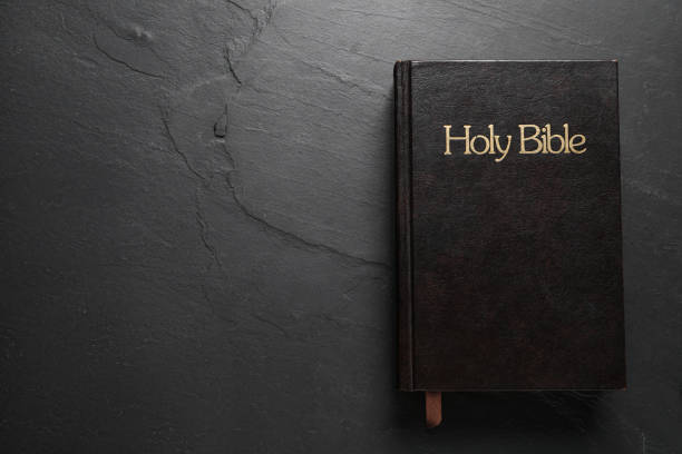 istock Hardcover Bible on black table, top view with space for text. Religious book 1791692192