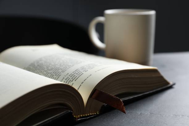 istock Open hardcover Bible on black table indoors, closeup. Religious book 1791692768