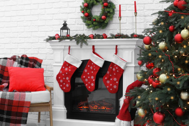 Cosy room with tree and fireplace decorated for Christmas. Interior design