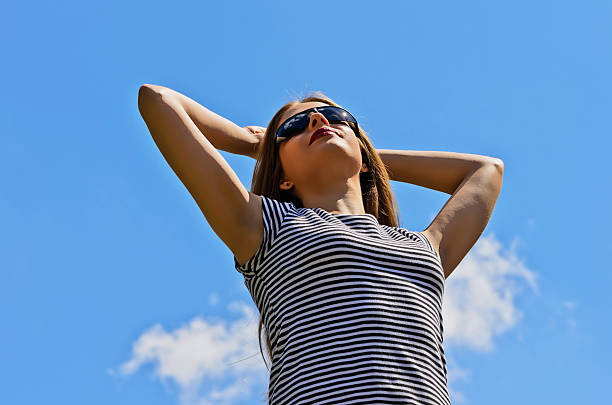 istock Girl with arms raised in sun glasses 179169727