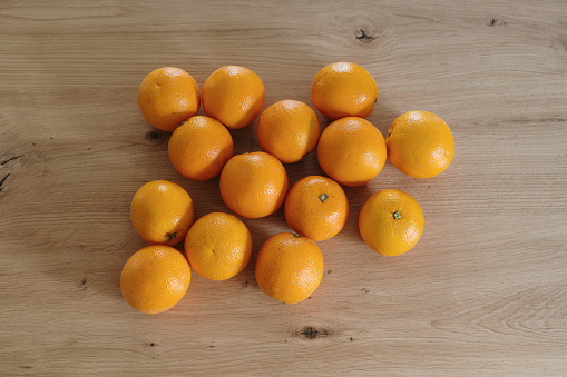 A large number of oranges on a wooden kitchen counter