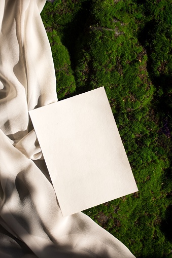 A white sheet of paper has a note tucked into it against a green backdrop
