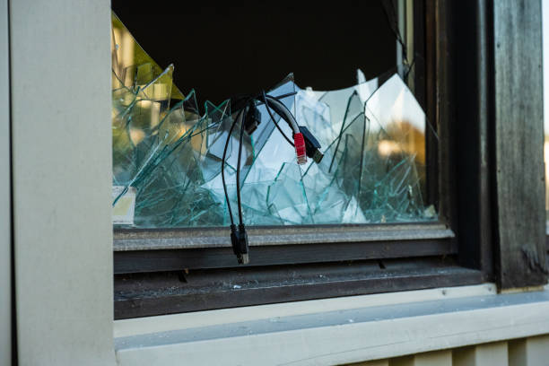 istock Computer cables hanging out of a broken window after a break in and theft.. 1791758015