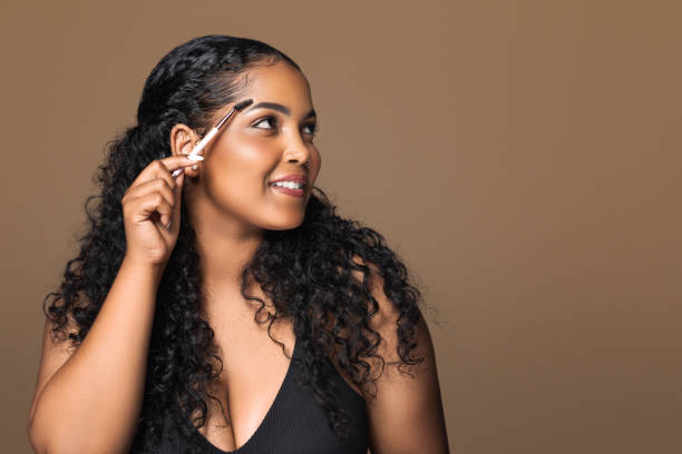 istock Eyebrow makeup. Latin plus size woman shaping brows with eyebrow brush, modeling brows, looking aside at free space 1791762347