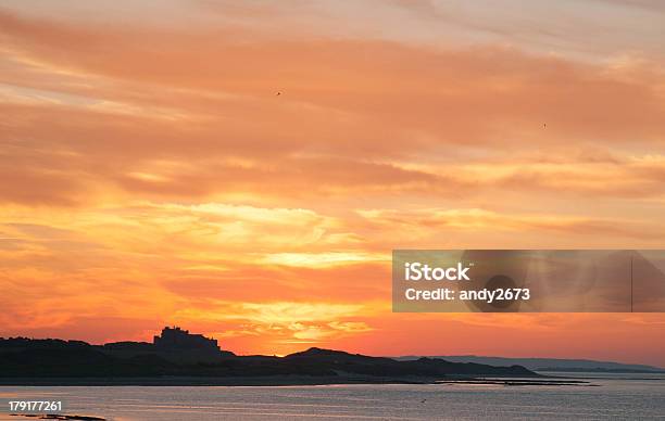 Foto de Pôr Do Sol Sobre O Castelo De Bamburgh e mais fotos de stock de Bamburgh - Bamburgh, Beleza, Castelo