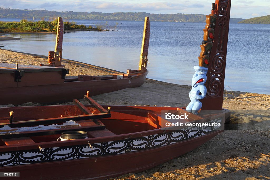 Maori boats Traditional Maori wood carved canoes on the shore in New Zealand Ancient Stock Photo