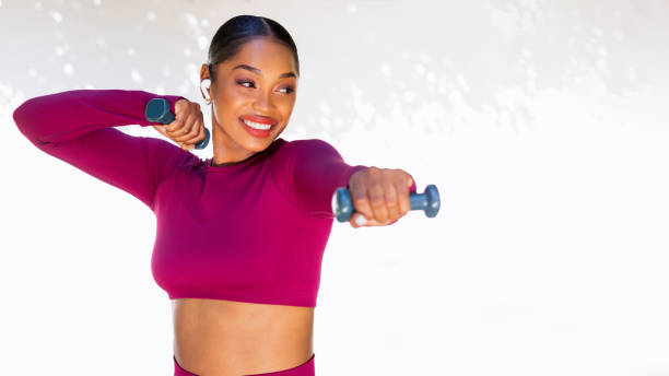 istock Strong young black woman doing exercises with dumbbells over white 1791795797